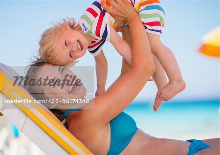 Portrait of mother playing with baby on beach