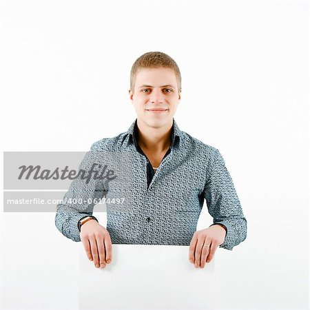 smiling young man with a white sheet of paper