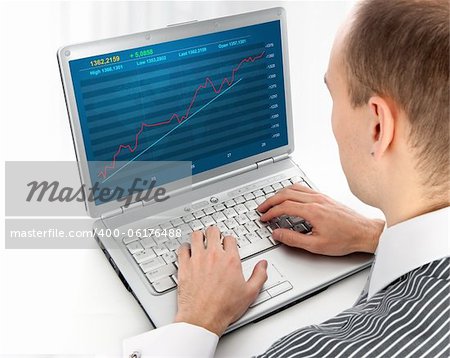 young man working of a laptop with Financial diagram