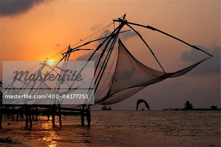 Sunset over Chinese Fishing nets and boat in Cochin (Kochi), Kerala, India.