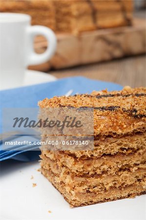 Traditional Honey Cake on Plate and White Cup of Coffee on Table