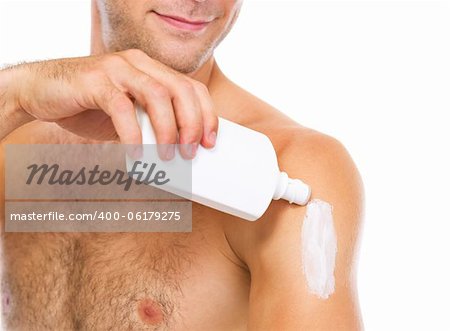 Closeup on man applying sun block creme on arm