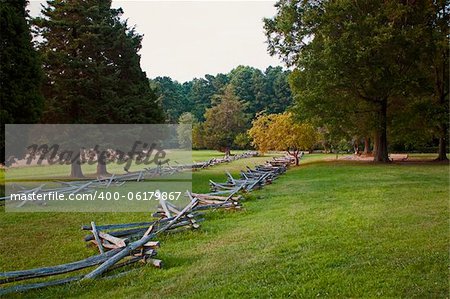 the Surrender Field at Yorktown National Battlefield, Virginia. It was here that the British Army under Cornwallis was defeated by a combined American / French force. Images shows the field at sunset, with rough cut wood fences, tree and a golden glow on the grass of this historic field