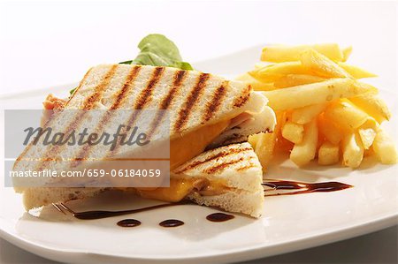 Sandwich fromage et jambon grillé avec des frites