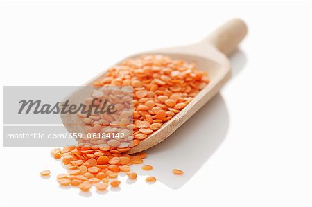 Red lentils in wooden scoop