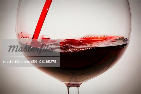 Gießen in einem Glas aus Flasche Rotwein