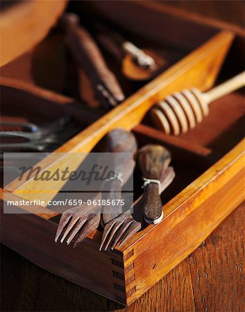 Old Wooden Spoons and Forks with Old Tools in a Wooden Box