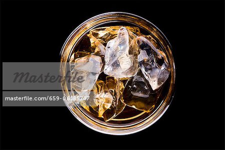 A glass of whiskey with ice cubes (seen from above)