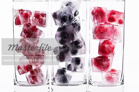 Three glasses with various berry ice cubes