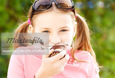 Une jeune fille mangeant une guimauve au chocolat