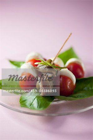 Un apéritif composé de sardines, olives, tomates et mozzarella