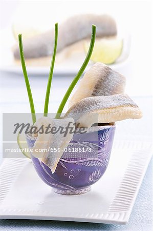 Soused herring fillets in a blue cup