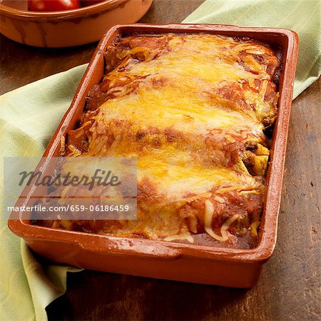 Baked Chicken Enchiladas with Melted Yellow and White Cheese; In Baking Dish