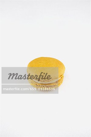 Un seul macaron citron sur fond blanc