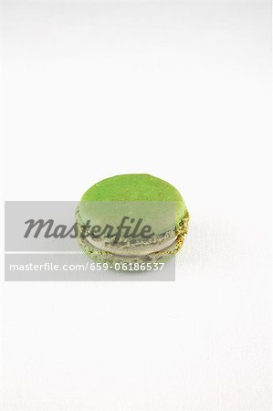 A Single Pistachio Macaroon on a White Background