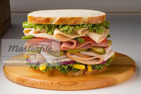 Large Chicken, Ham and Turkey Sandwich with Veggies on White Bread