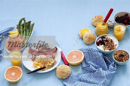 Ein Frühstückstisch legte mit Rührei und Speck, Lachs, Müsli, Marmelade und grapefruit