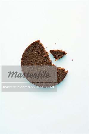 Eine Scheibe Pumpernickel Brot mit einem Biss herausgenommen