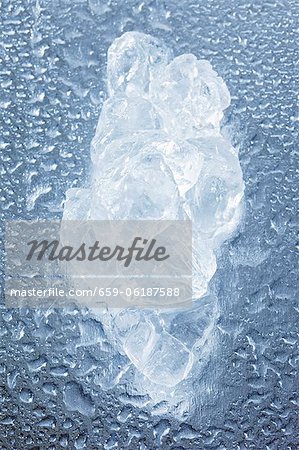 A piece of ice on a wet surface A piece of ice on a wet surface