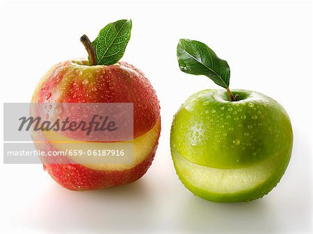 A red and a green apples with a slice taken out of each