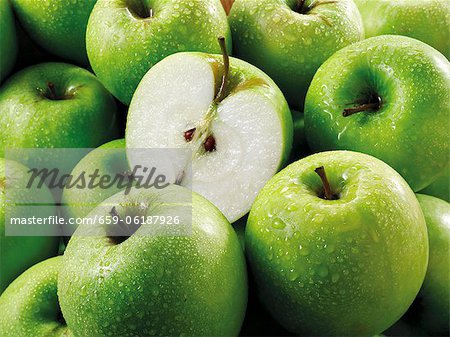 Pommes Granny Smith, les entiers et les moitiés (remplit l'écran) Pommes Granny Smith, les entiers et les moitiés (remplit l'écran)