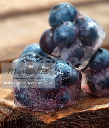 Ice cubes with blueberries on a wooden table