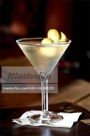 Martini avec Olives vertes ; Sur une serviette de table de Cocktail Martini avec Olives vertes ; Sur une serviette de table de Cocktail