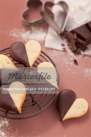 Heart-shaped biscuits with chocolate icing on a wire rack