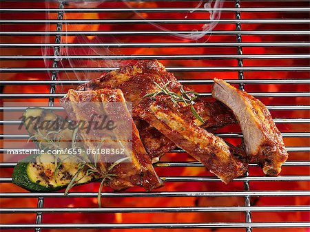 Spare ribs on a grill with vegetables