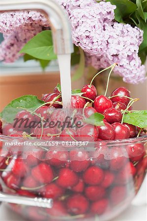 Cherries being washed under running water