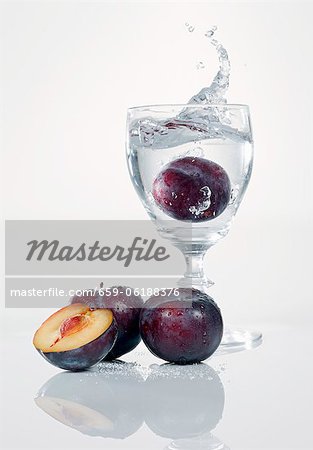 A damson falling into a schnapps glass A damson falling into a schnapps glass