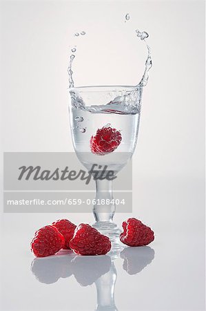 Une framboise tomber dans un verre