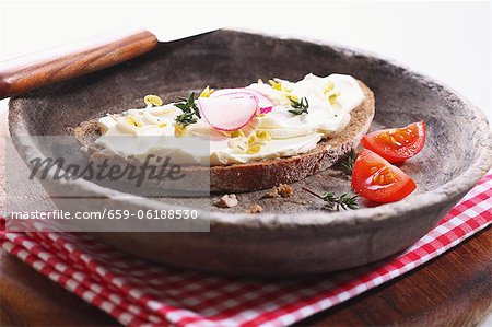 Une tranche de pain garnie de fromage à la crème, les germes de haricots et les radis Une tranche de pain garnie de fromage à la crème, les germes de haricots et les radis