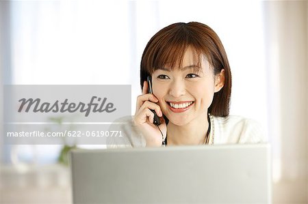 Femme japonaise souriante parlant au téléphone cellulaire