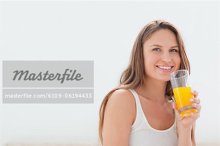 Femme souriante, boire un jus d'orange