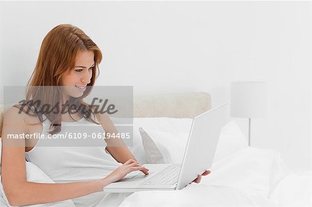 Smiling redheaded woman using a laptop