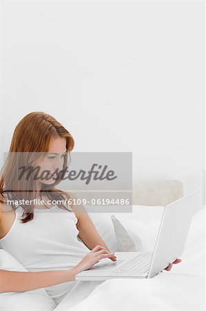 Belle femme rousse à l'aide d'un ordinateur portable
