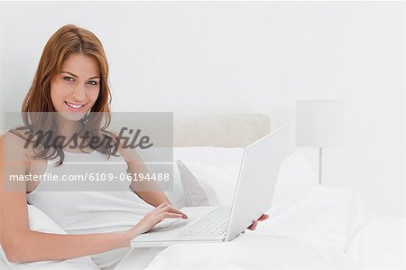 Porträt einer attraktiven Rothaarigen Frau, die mit einem laptop