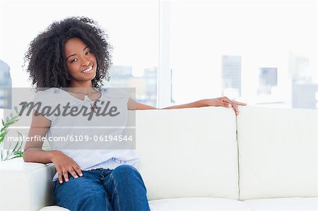 Femme souriante assise sur un canapé