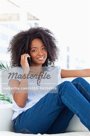 Portrait of a woman with fuzzy hair sitting making a call