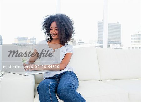 Fuzzy hair woman tapping on her computer