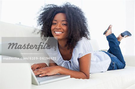 Portrait of a laughing fuzzy hair woman surfing the internet