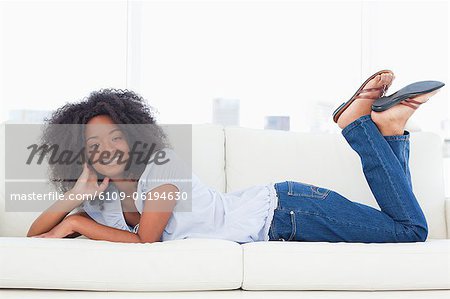 Portrait d'une femme brune cool sur son canapé