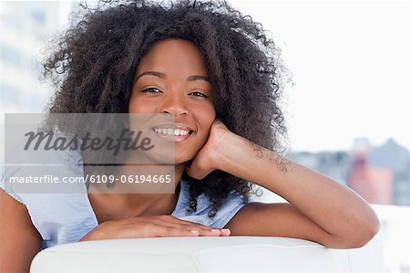 Porträt einer glücklichen Frau auf ihrem Sofa liegend