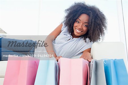 Portrait of a smiling fuzzy hair woman looking into her shopping bags