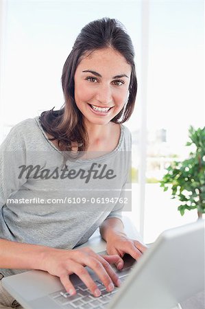 Portrait d'un élève radieux à l'aide d'un ordinateur portable