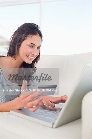 Close-up of a smiling student using her credit card online