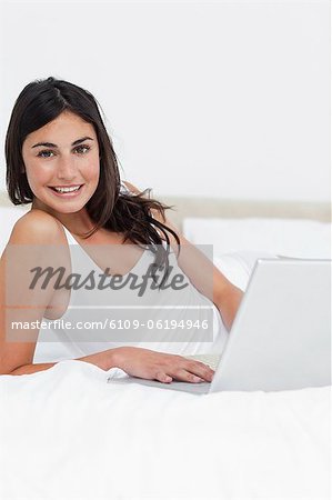 Portrait of a smiling brunette using her laptop
