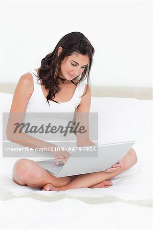 Brunette avec un ordinateur portable sur les genoux