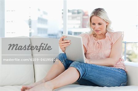 Blonde Hausfrau mit einem touchpad